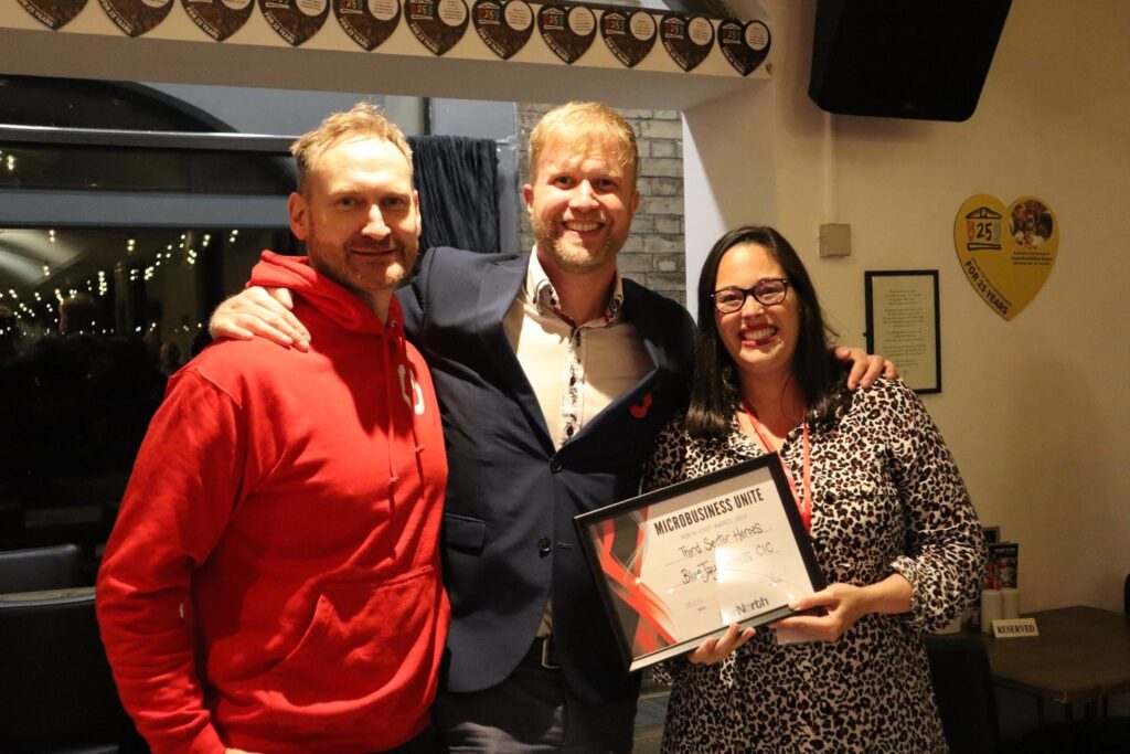 Lisa Cryer from BlueJay Wellness (right) being presented with the Third Sector Heroes Award at the Microbusiness Unite Event by Ian Farrar (left) and Adam Corbally - BBC's The Apprentice Finalist (centre).