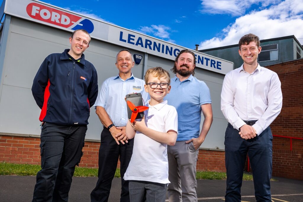 Isaac shows off his windmirrors invention alongside (l-r) Nathan McCully, QHS and Environmental Manager at Ford Aerospace, Eddie Czestochowski, Managing Director at Cell Pack Solutions, Chris Ford of Ford Aerospace and Harry Chadwick, Communications Officer at the Dogger Bank Wind Farm.